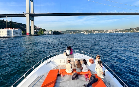 Passengers on yacht viewing Bosphorus Bridge in Istanbul.