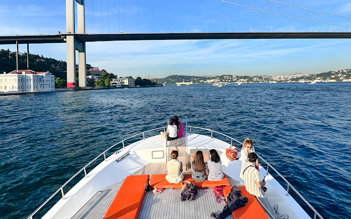 Passengers on yacht viewing Bosphorus Bridge in Istanbul.