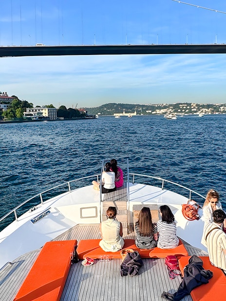 Passengers on yacht viewing Bosphorus Bridge in Istanbul.