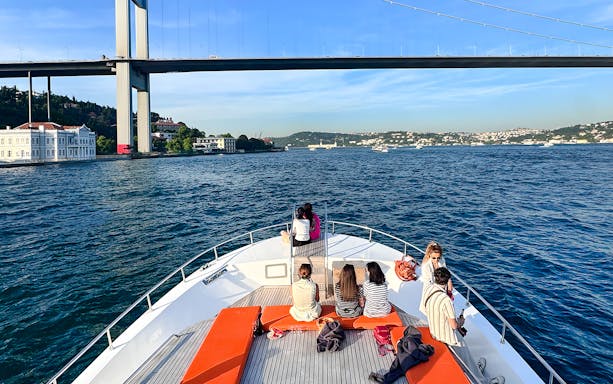 Passengers on yacht viewing Bosphorus Bridge in Istanbul.