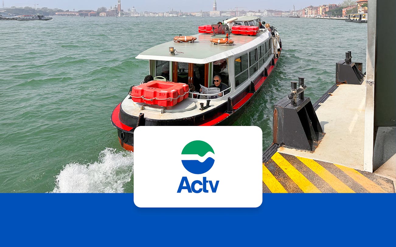 Venice ACTV water bus approaching dock with cityscape in background.
