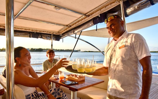 Guests enjoying drinks on a Sabre sunset cruise with BBQ dinner.