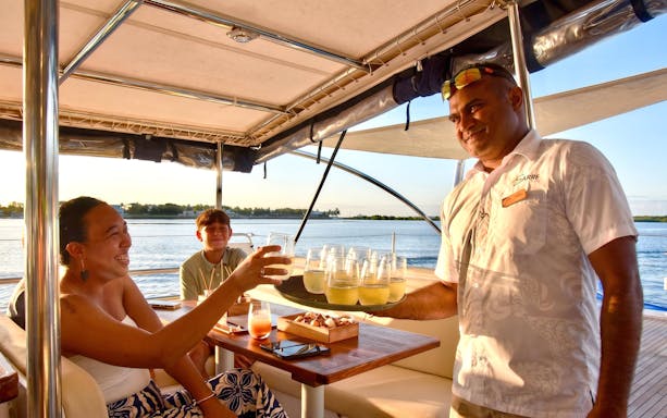 Guests enjoying drinks on a Sabre sunset cruise with BBQ dinner.