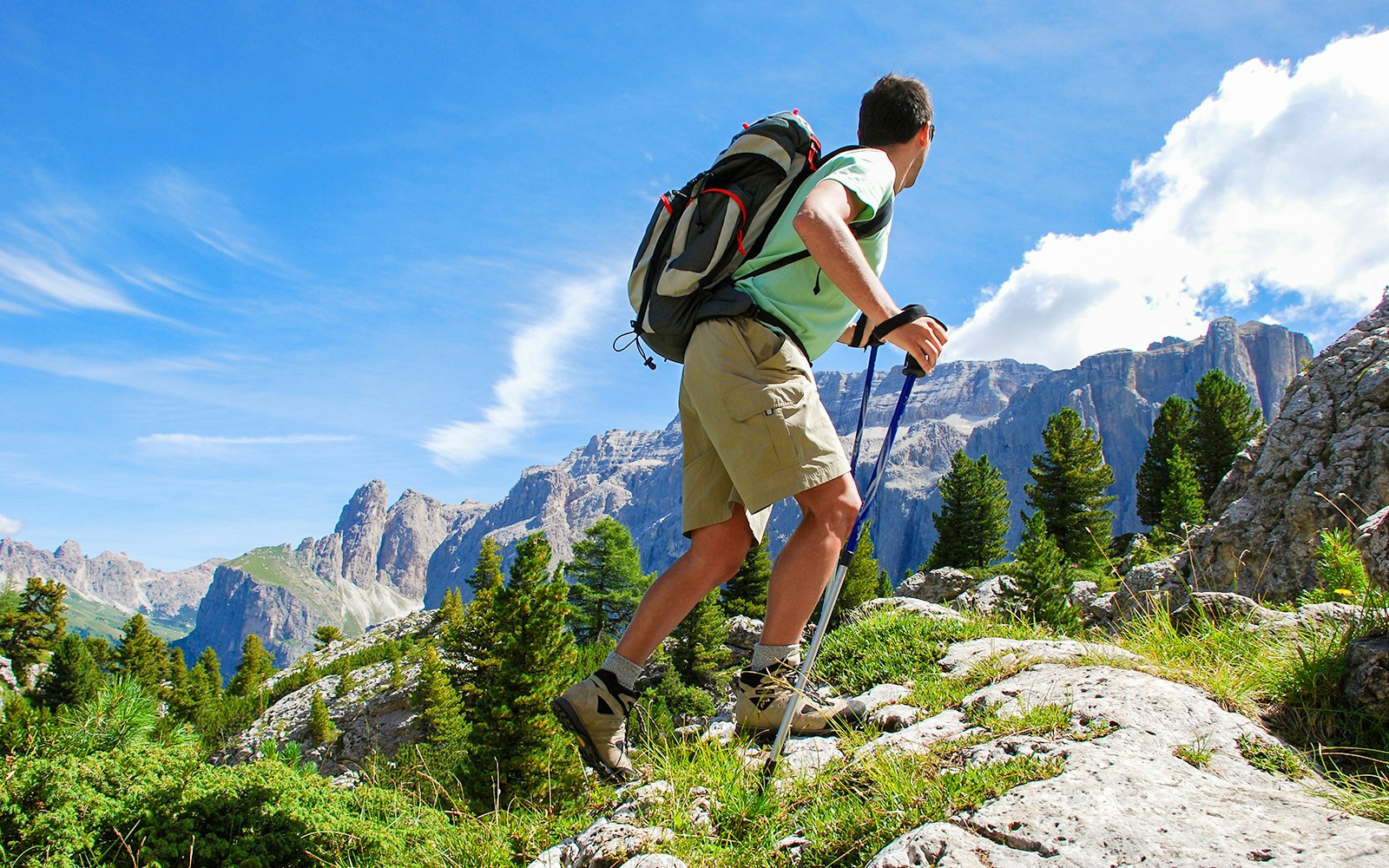 Hikers on Marmot Nature Trail with alpine views in Grindelwald First, Switzerland.