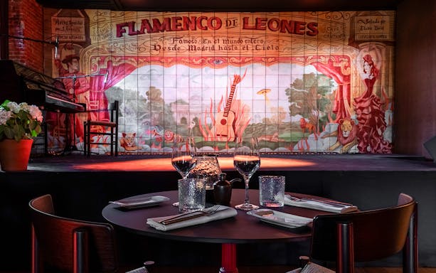 Flamenco De Leones stage with painted backdrop and dining table, Madrid.