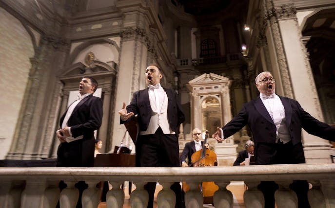 Three tenors performing in a historic Florence venue during a Tuscan dinner concert.