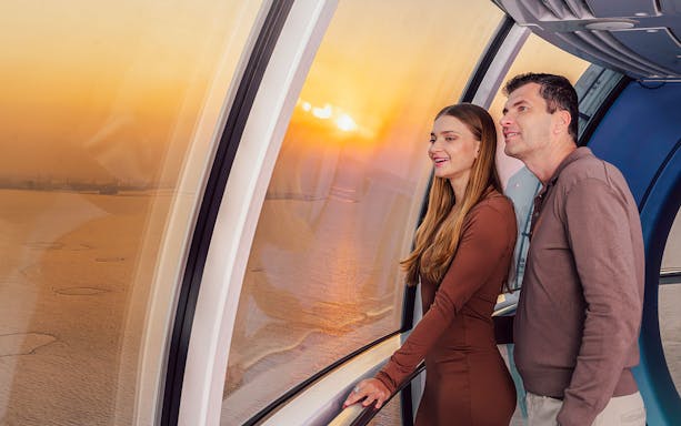 Visitors enjoying sunset views inside Ain Dubai observation wheel.
