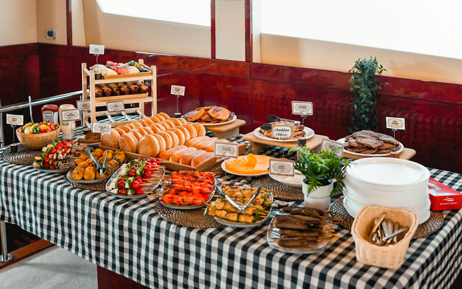 Breakfast buffet on a luxury yacht with assorted pastries, fruits, and cheeses.