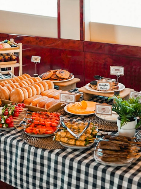 Breakfast buffet on a luxury yacht with assorted pastries, fruits, and cheeses.