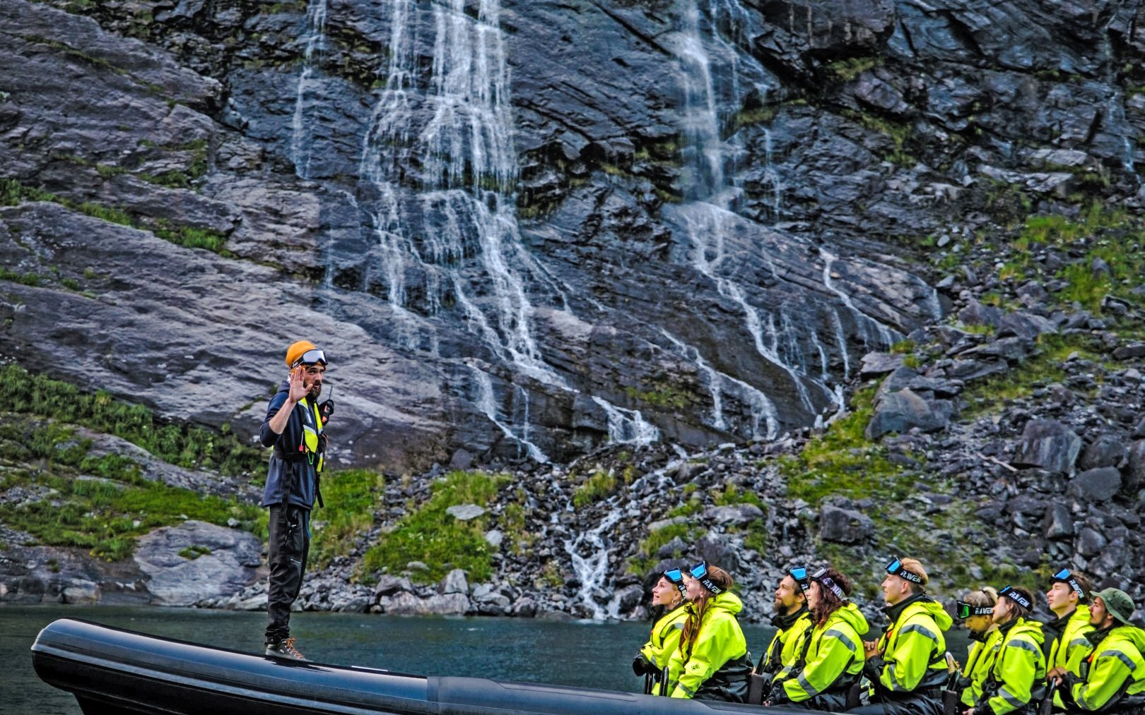 Tourists on a RIB boat near Hellesylt waterfall during a Geiranger fjord safari.