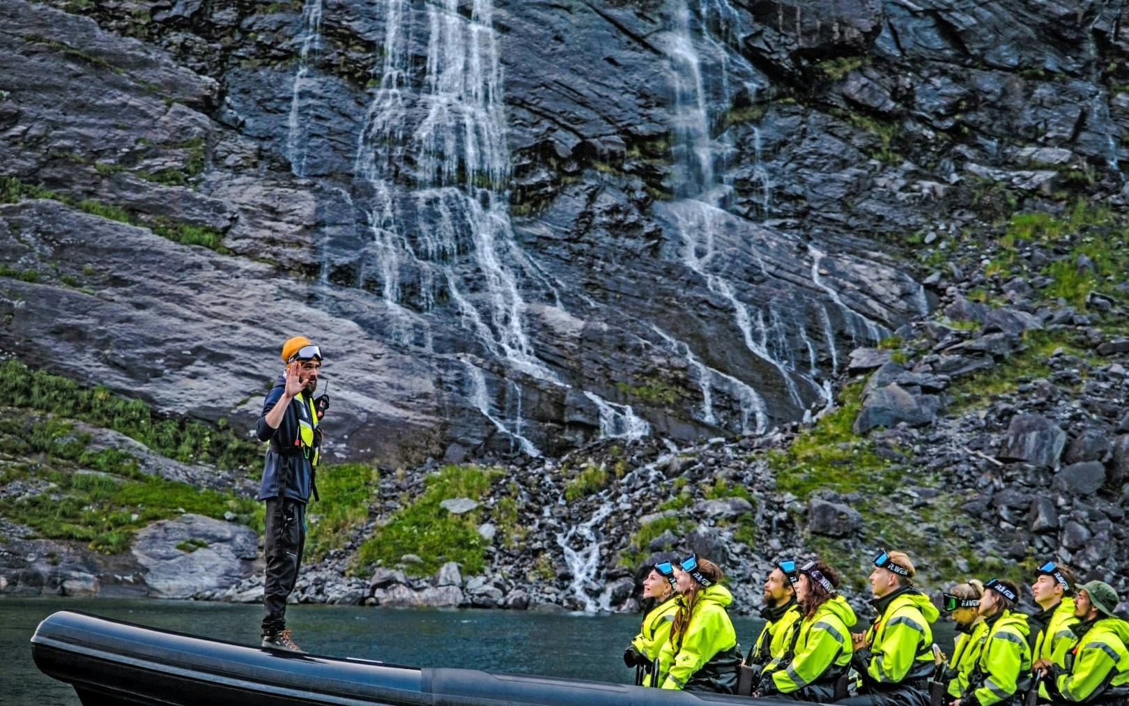 Tourists on a RIB boat near Hellesylt waterfall during a Geiranger fjord safari.