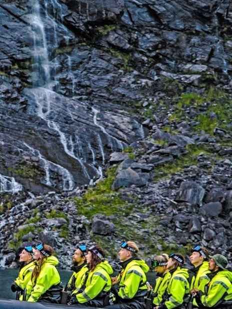 Tourists on a RIB boat near Hellesylt waterfall during a Geiranger fjord safari.
