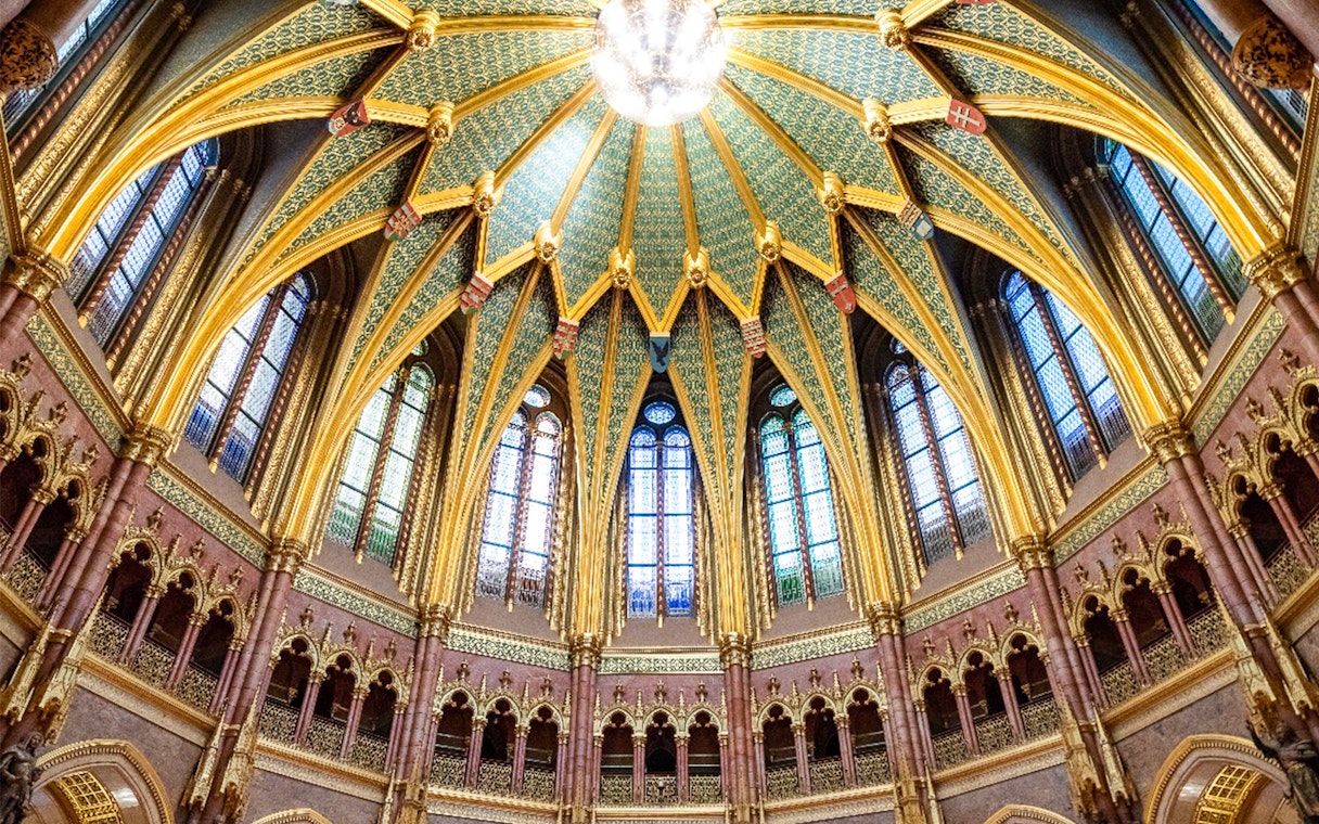 Ceiling of the Dome Hall in the Hungarian Parliament, Budapest, featuring ornate arches and stained glass.