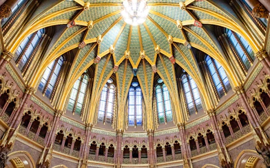 Ceiling of the Dome Hall in the Hungarian Parliament, Budapest, featuring ornate arches and stained glass.