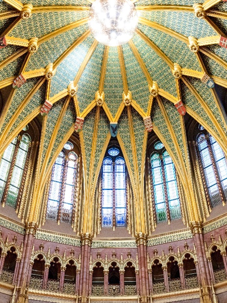 Ceiling of the Dome Hall in the Hungarian Parliament, Budapest, featuring ornate arches and stained glass.