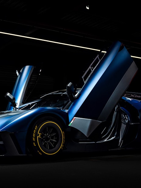 Sleek blue sports car with open doors at Coligny Car Museum, Lyon, France.