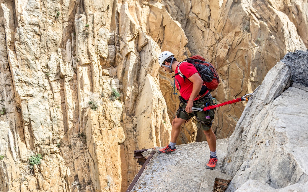 Man rappelling down Caminito del Rey in safety gear, Spain.