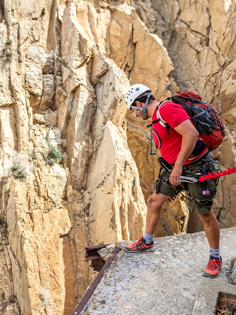 Man rappelling down Caminito del Rey in safety gear, Spain.