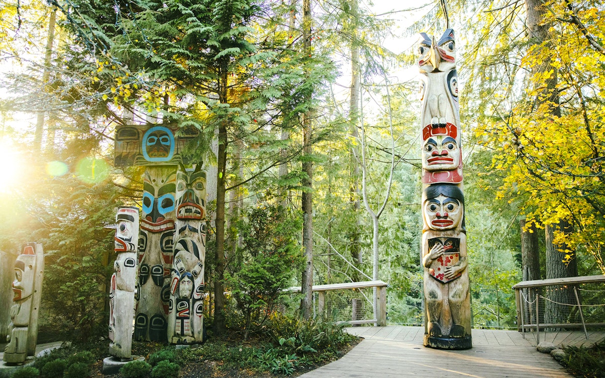 Totem poles surrounded by forest at Capilano Suspension Bridge Park.