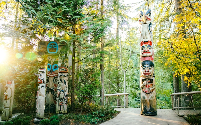 Totem poles surrounded by forest at Capilano Suspension Bridge Park.