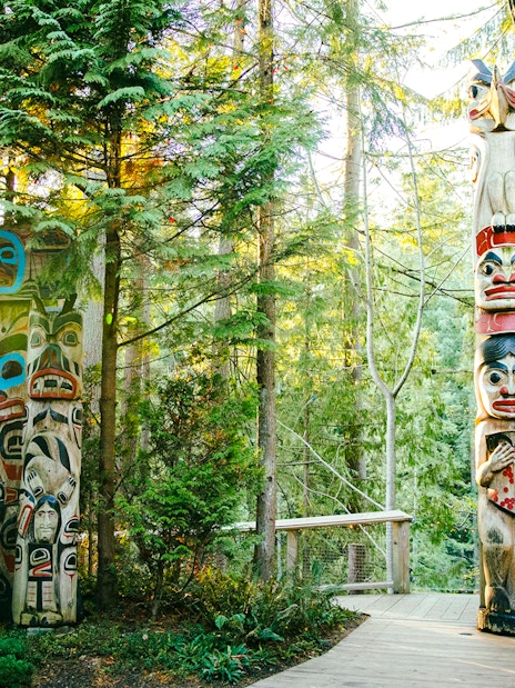 Totem poles surrounded by forest at Capilano Suspension Bridge Park.