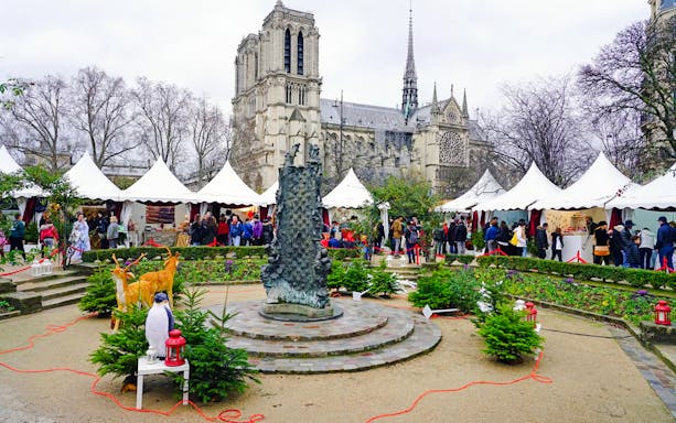 Paris Christmas Market with festive stalls near Notre-Dame Cathedral.