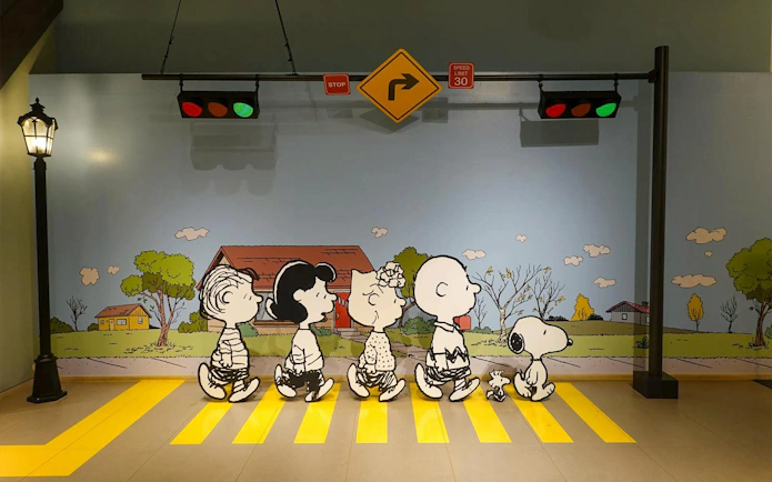 Peanuts characters crossing a yellow path at Snoopy Garden Jeju.