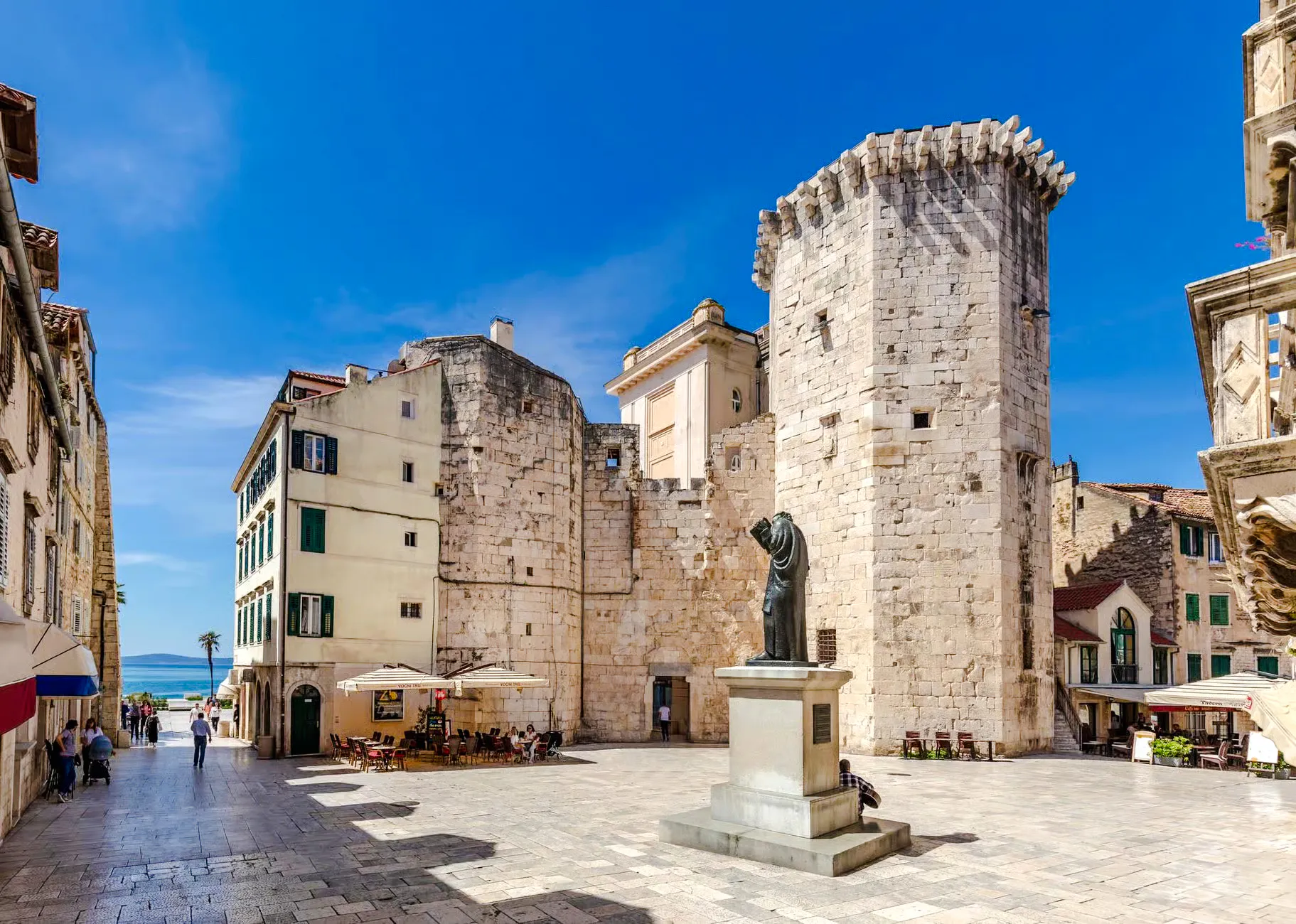 Diocletian's Palace courtyard with statue and ancient stone walls, Split.