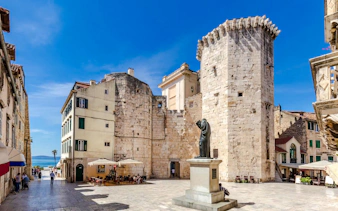 Diocletian's Palace courtyard with statue and ancient stone walls, Split.