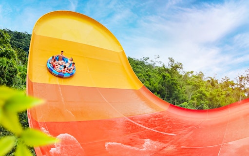 People enjoying a large waterslide at Water World Ocean Park, Hong Kong.