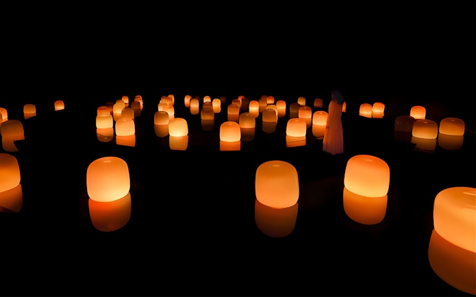 Glowing orange lanterns in a dark room at TeamLab Phenomena Abu Dhabi.
