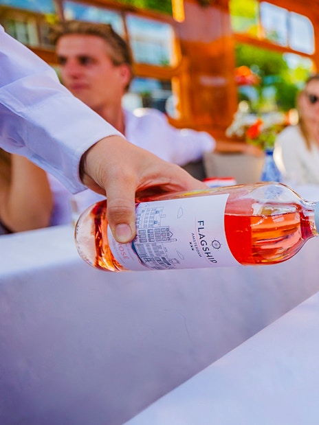 Wine being poured into a glass with cheese platter on a luxury cruise in Amsterdam.
