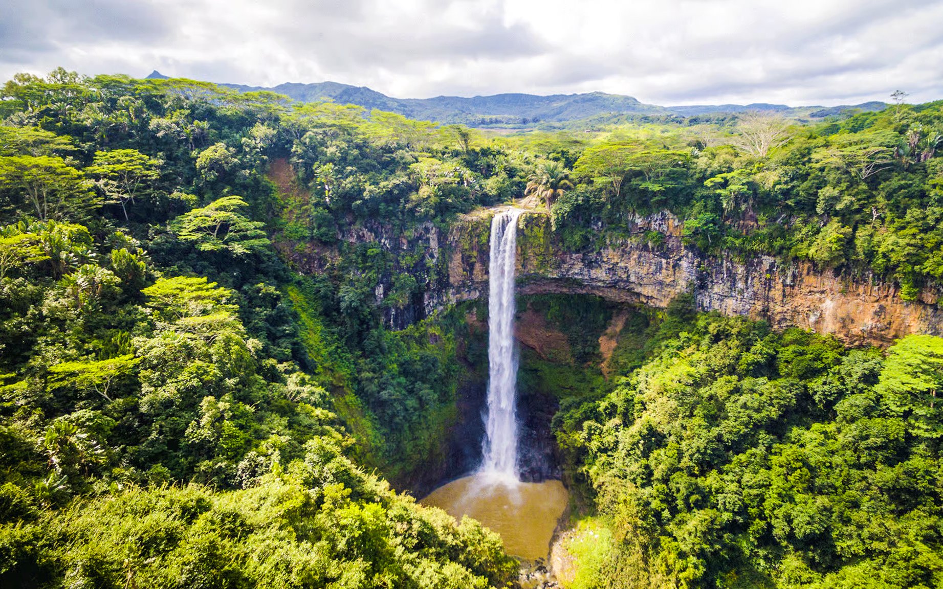 Chamarel Waterfall cascading into lush green forest, Mauritius.