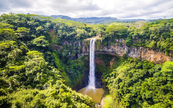Chamarel Waterfall cascading into lush green forest, Mauritius.