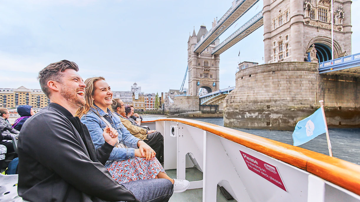 Tourists enjoying a boat ride near Tower Bridge, London on Big Bus: Big Day Out.