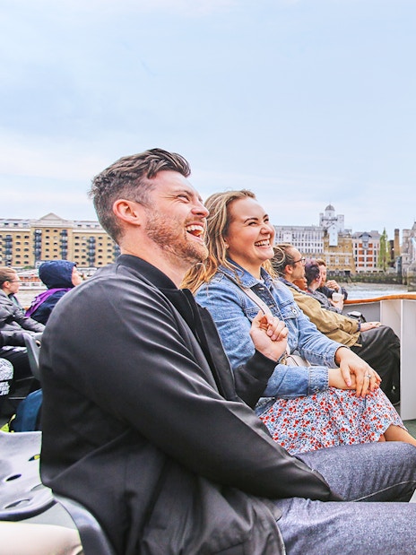 Tourists enjoying a boat ride near Tower Bridge, London on Big Bus: Big Day Out.