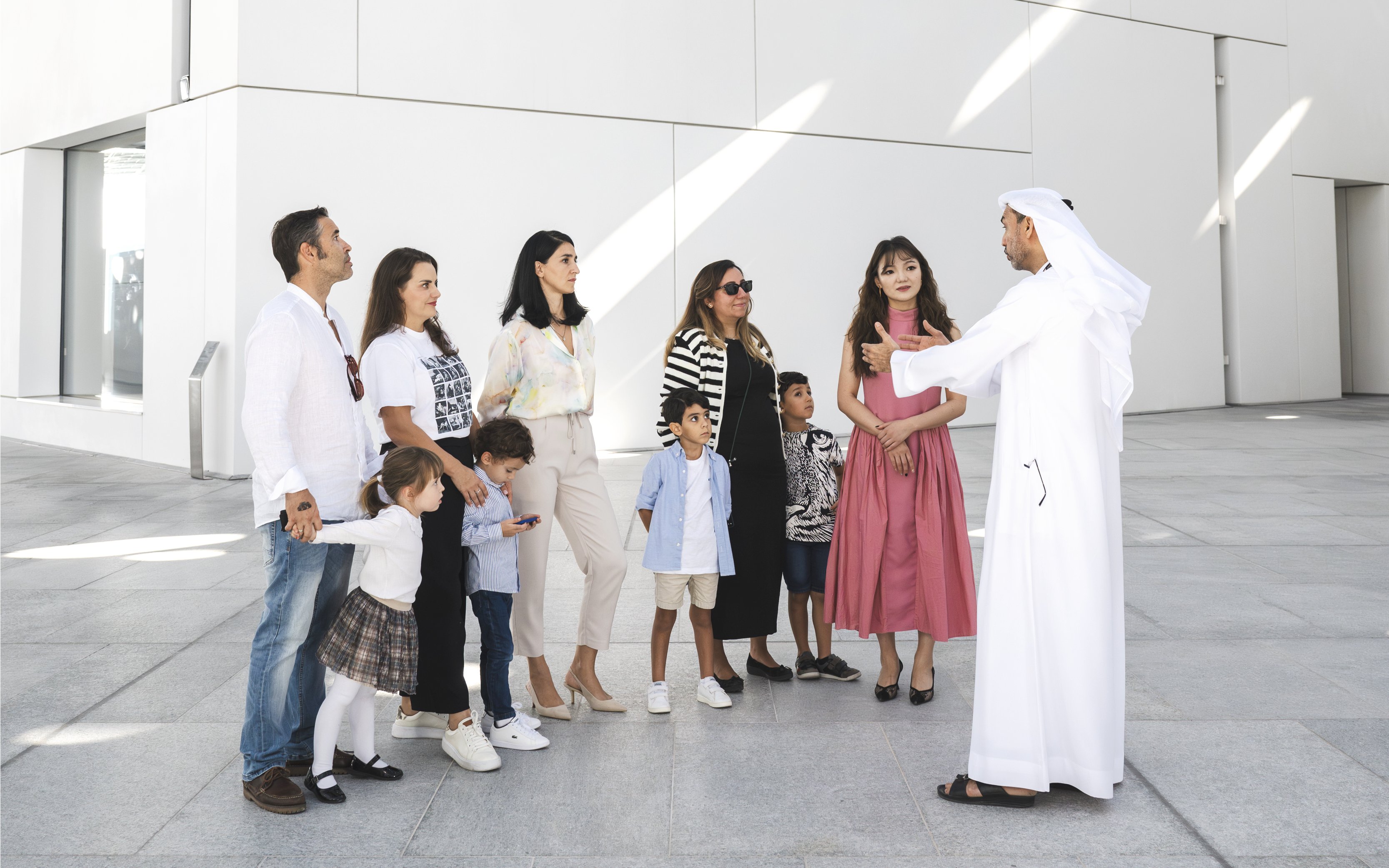Family with guide at Louvre Abu Dhabi courtyard.