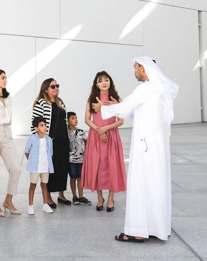 Family with guide at Louvre Abu Dhabi courtyard.
