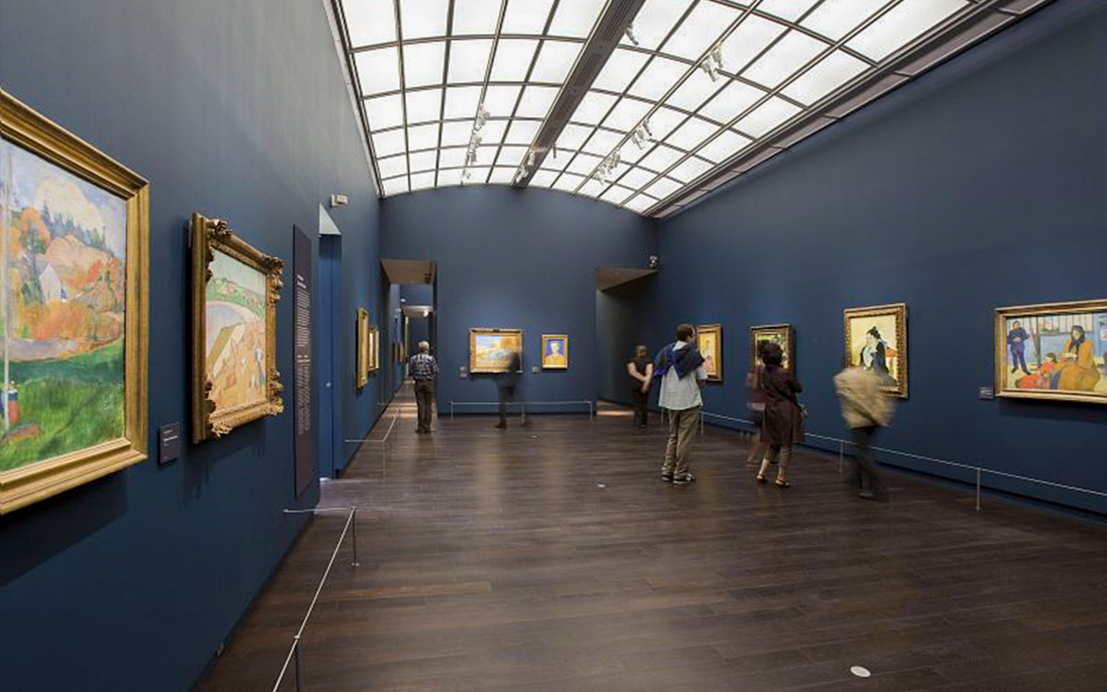 Visitors exploring art at Orsay Museum, Paris, during a guided tour focused on Impressionist masterpieces.