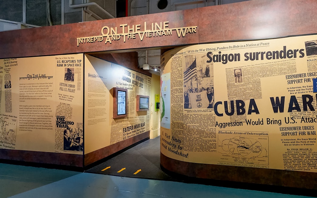 Intrepid Museum's "On the Line" exhibit featuring Vietnam War newspaper headlines.