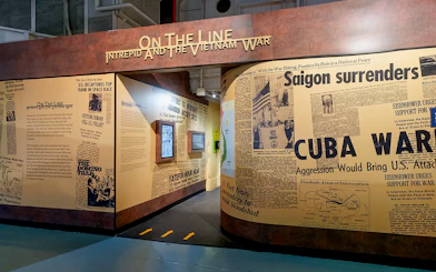 Intrepid Museum's "On the Line" exhibit featuring Vietnam War newspaper headlines.