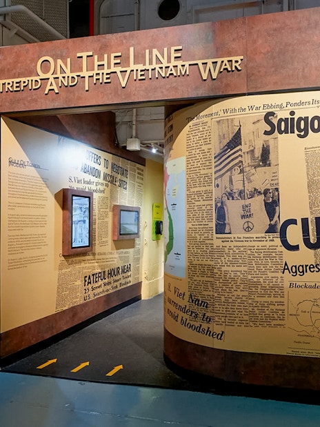 Intrepid Museum's "On the Line" exhibit featuring Vietnam War newspaper headlines.