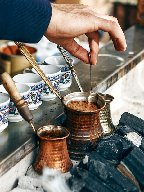 Brewing Turkish coffee in copper pots over hot coals, Istanbul.