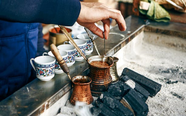 Brewing Turkish coffee in copper pots over hot coals, Istanbul.