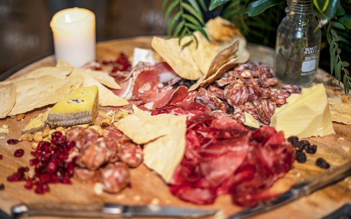 Charcuterie board with assorted meats, cheeses, nuts, and dried fruits in Sydney.
