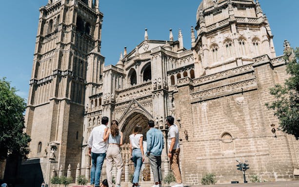 Group visiting Toledo Cathedral in Spain, admiring its Gothic architecture.