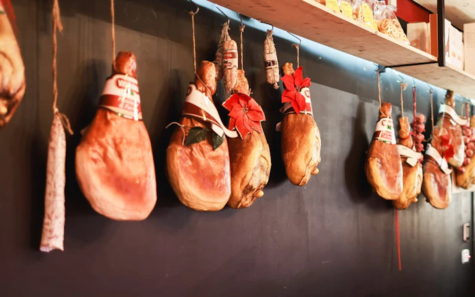 Cured meats hanging in a Verona shop, part of the Romeo & Juliet food tour.