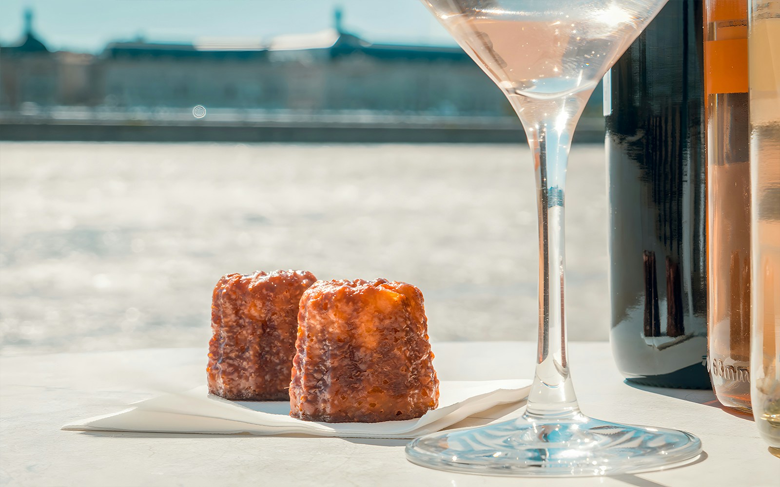 Canelés and wine glass on Bordeaux River Cruise table.