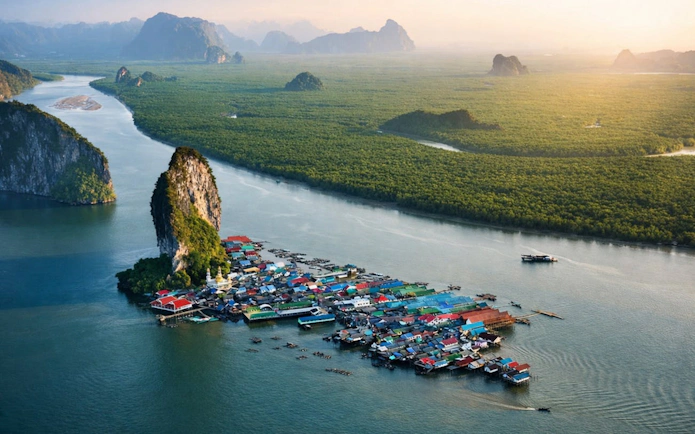 James Bond Island with floating village and limestone cliffs, Phang Nga Bay, Thailand.