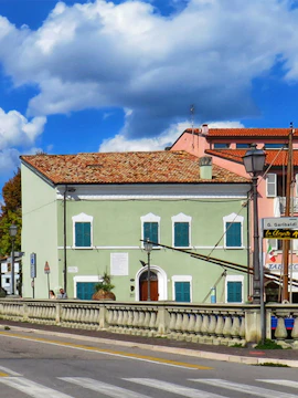 Marino Moretti House with green facade and blue shutters in Cesenatico, Italy.